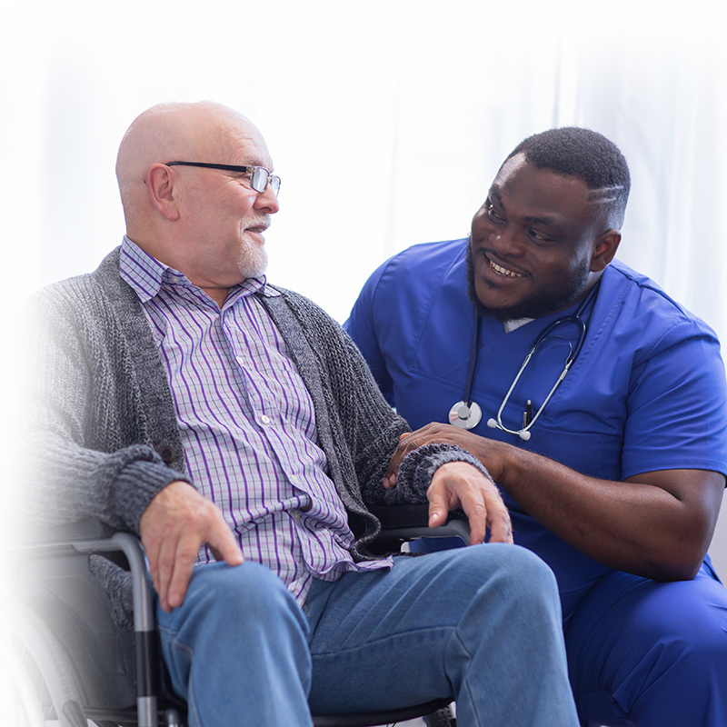 rehab therapist talking to a resident in the rehab gym